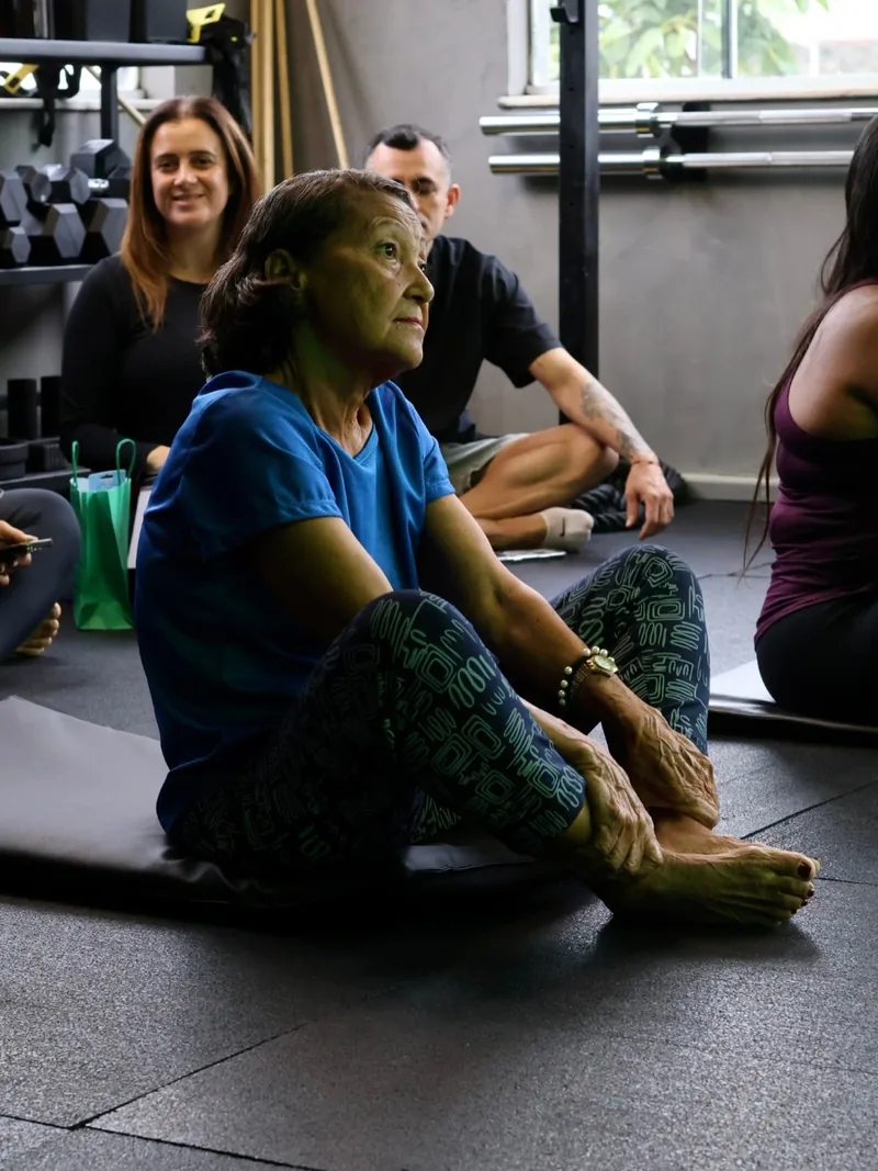 Participantes sentados em roda em uma vivência conduzida em um studio de treino